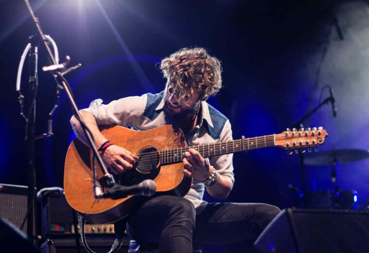 man-playing-guitar-sitting-on-chair-1425297