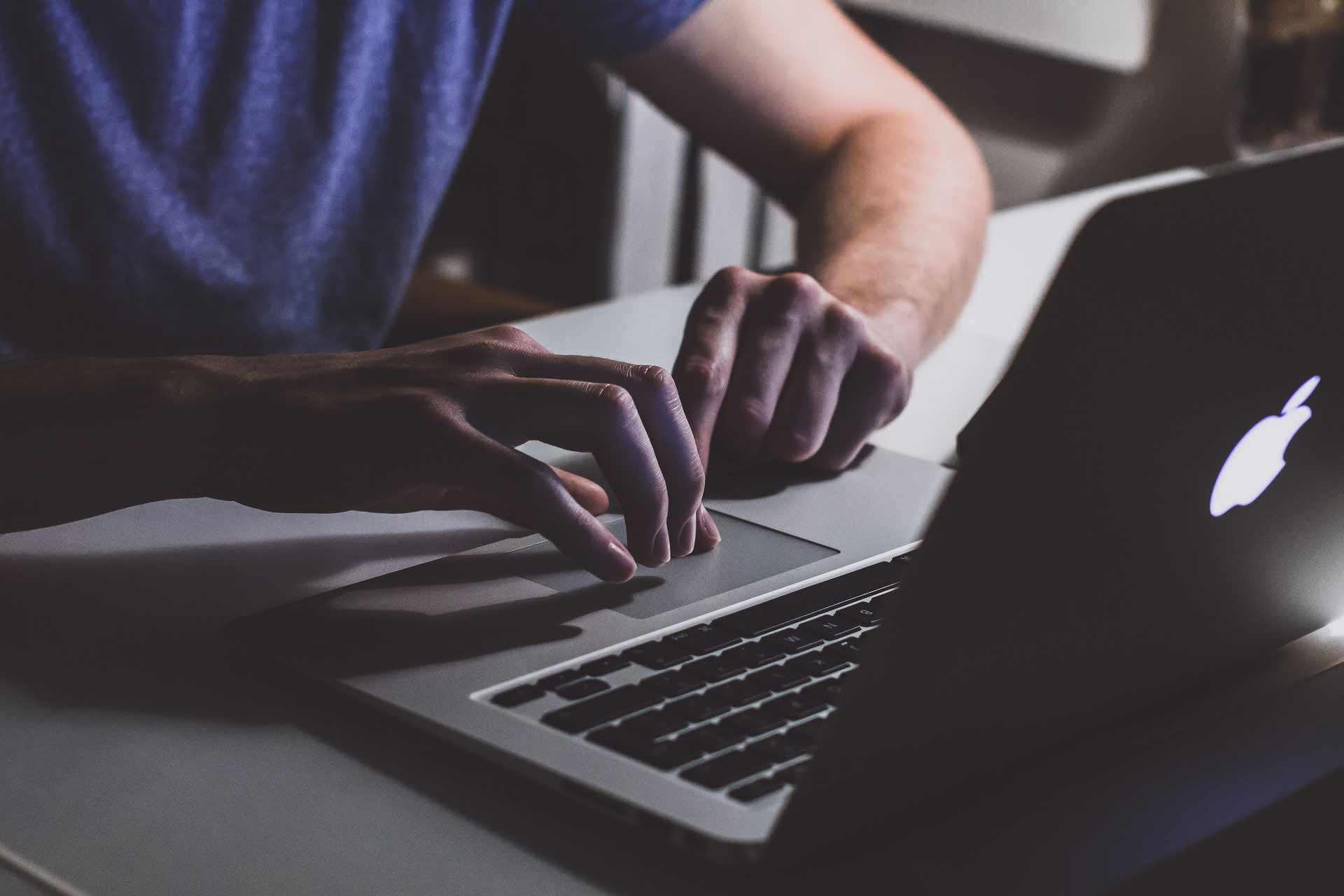 person-touching-open-macbook-on-table-839465