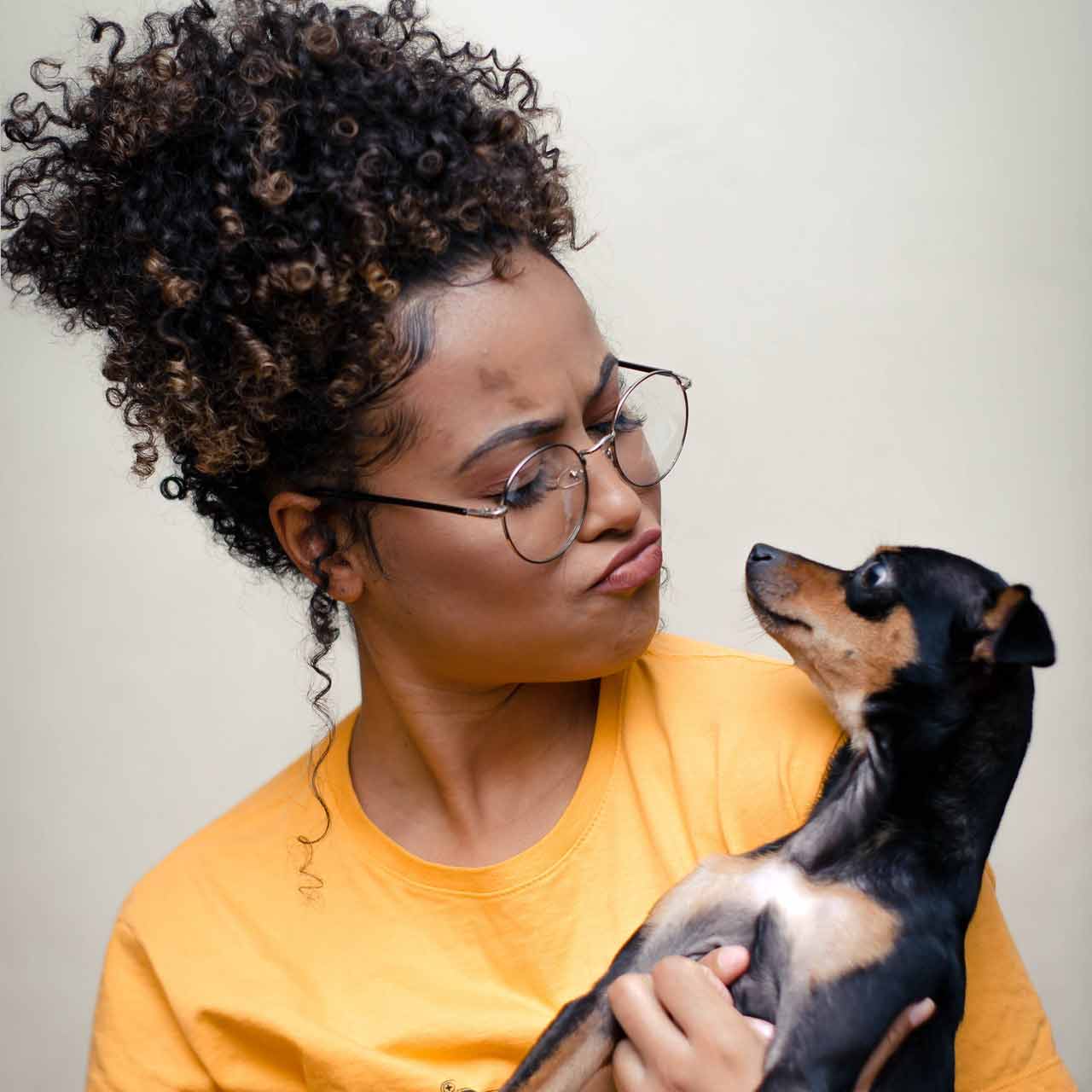 woman-holding-short-coated-black-and-brown-puppy-3190736